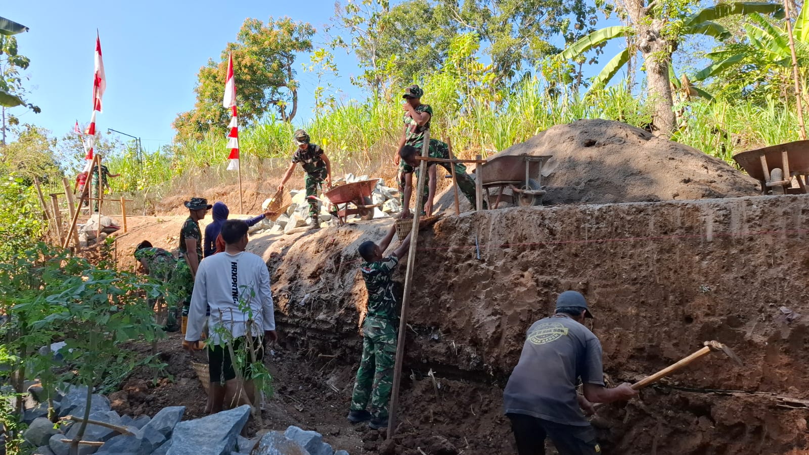 Kekompakan Warga Masyarakat Bersama  TNI Satgas TMMD ke-129 Kodim 0802/Ponorogo Percepat Galian Pondasi Talud
