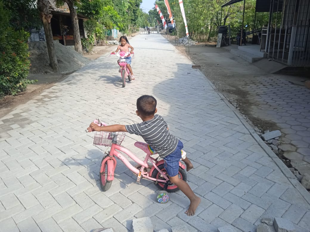 Terlihat Ekspresi Girang Anak-Anak Naik Sepeda Diatas Paving Pembangunan TMMD Ke-129 Kodim 0802/Ponorogo