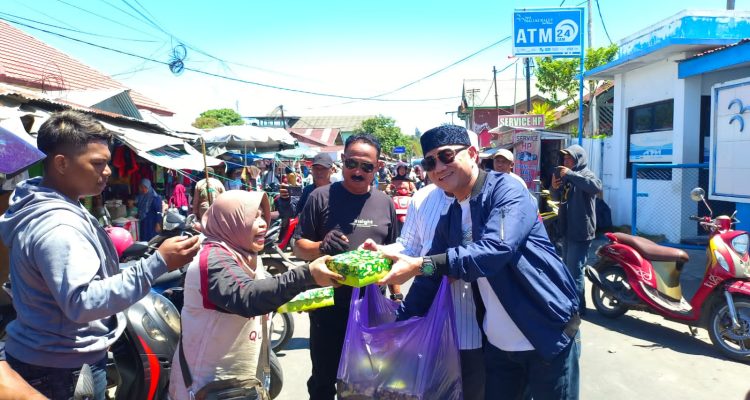 Pembagian nasi kotak oleh MDR selalu Ketua DPD partai Nasdem Kabupaten Buru, di Pasar Inpres Namlea, Jumat (3/11).